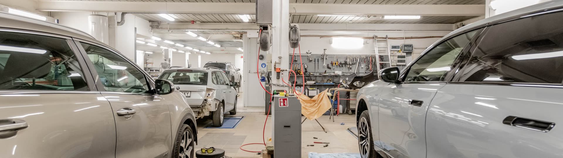 Verkstadsgolvet med flera bilar inne på arbetsplatserna.